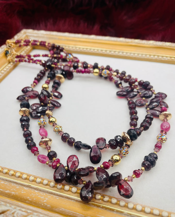 Nested 3 strand necklace featuring garnets, rubies, purple crystals, 14K gold accents, and African brass spacers. Available only from Rockstar Cowgirl online or in store in Cody, Wyoming.