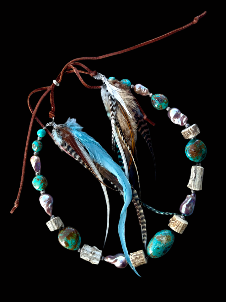 Hatband or necklace featuring Kingman turquoise nuggets, natural luster baroque pearls, deer antler, sterling silver beads sprinkled throughout and finished with feathers, deer lace and a sliding bead for fit. Available only from Rockstar Cowgirl online or in store in Cody, Wyoming.