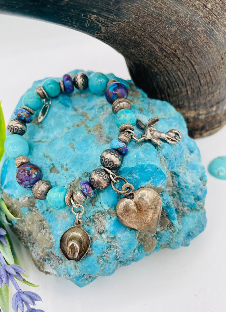 Stretch bracelet featuring Kingman turquoise, purple Mojave turquoise, sterling silver beads, and vintage sterling silver charms. Available only from Rockstar Cowgirl online or in store in Cody, Wyoming.