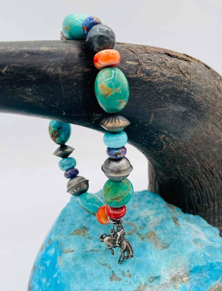 Stretch bracelet featuring purple Mojave turquoise, Kingman turquoise, spiney oyster, sterling silver beads, and a vintage sterling silver charm. Available only from Rockstar Cowgirl online or in store in Cody, Wyoming.