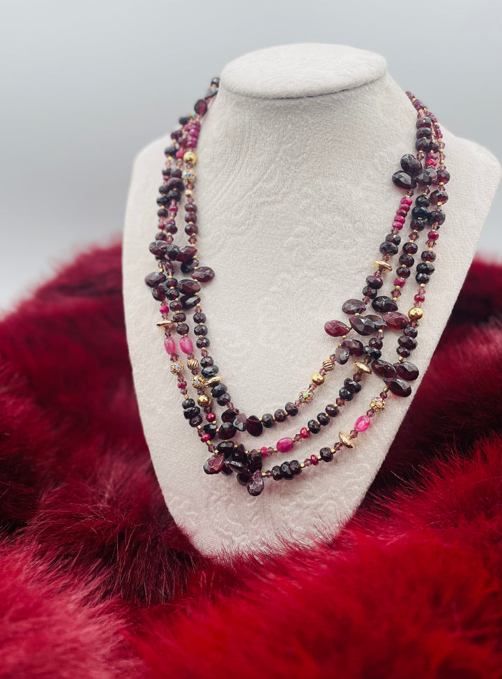 Nested 3 strand necklace featuring garnets, rubies, purple crystals, 14K gold accents, and African brass spacers. Available only from Rockstar Cowgirl online or in store in Cody, Wyoming.