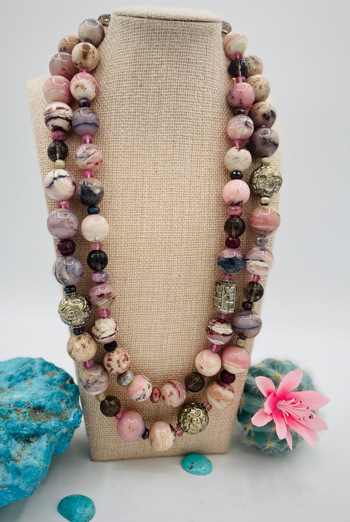 Beaded necklace featuring pink opal, repousse beads, smokey quartz, ruby, pink topaz, sterling silver beads, moonstone, and finished with deer lace in the back. Available only from Rockstar Cowgirl online or in store in Cody, Wyoming.