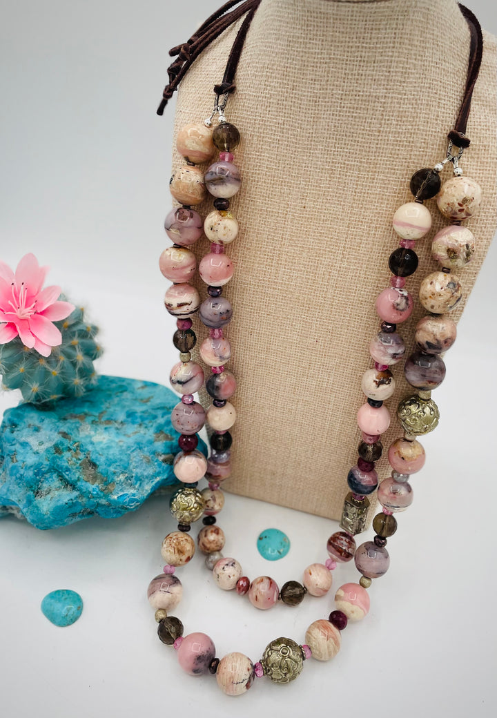 Beaded necklace featuring pink opal, repousse beads, smokey quartz, ruby, pink topaz, sterling silver beads, moonstone, and finished with deer lace in the back. Available only from Rockstar Cowgirl online or in store in Cody, Wyoming.