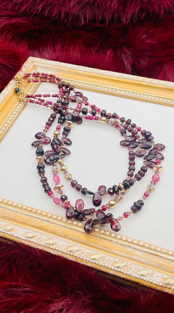 Nested 3 strand necklace featuring garnets, rubies, purple crystals, 14K gold accents, and African brass spacers. Available only from Rockstar Cowgirl online or in store in Cody, Wyoming.