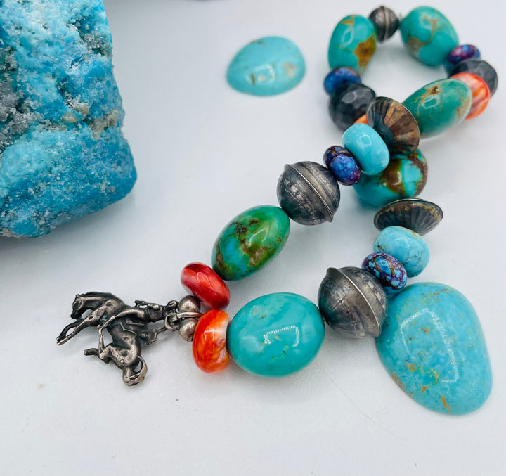 Stretch bracelet featuring purple Mojave turquoise, Kingman turquoise, spiney oyster, sterling silver beads, and a vintage sterling silver charm. Available only from Rockstar Cowgirl online or in store in Cody, Wyoming.