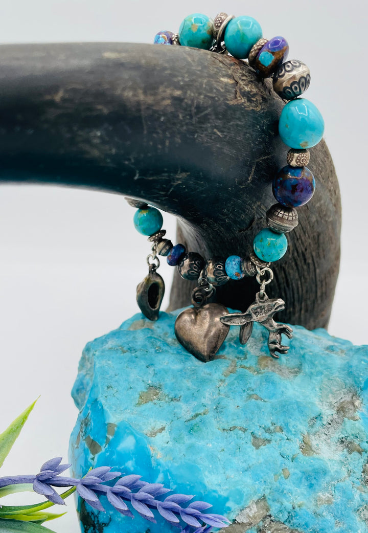 Stretch bracelet featuring Kingman turquoise, purple Mojave turquoise, sterling silver beads, and vintage sterling silver charms. Available only from Rockstar Cowgirl online or in store in Cody, Wyoming.