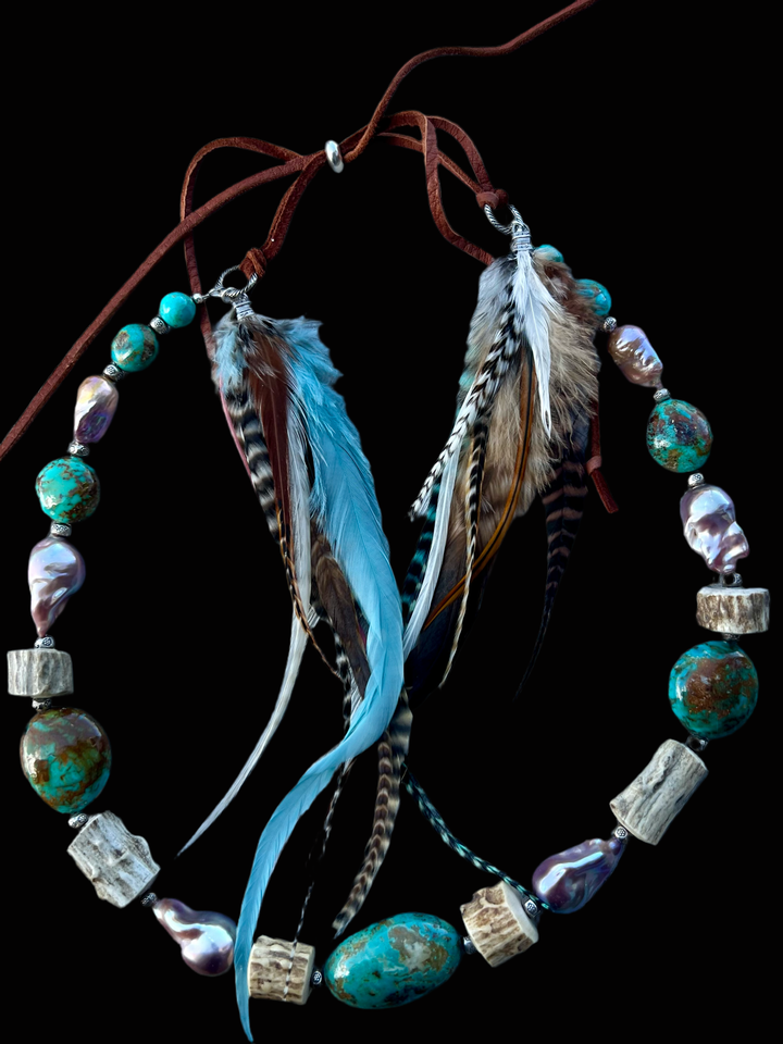 Hatband or necklace featuring Kingman turquoise nuggets, natural luster baroque pearls, deer antler, sterling silver beads sprinkled throughout and finished with feathers, deer lace and a sliding bead for fit. Available only from Rockstar Cowgirl online or in store in Cody, Wyoming.