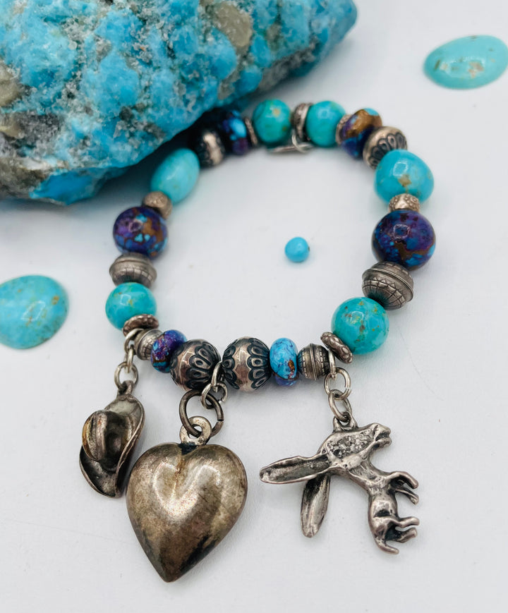 Stretch bracelet featuring Kingman turquoise, purple Mojave turquoise, sterling silver beads, and vintage sterling silver charms. Available only from Rockstar Cowgirl online or in store in Cody, Wyoming.