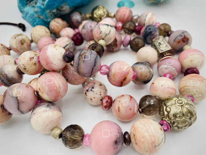 Beaded necklace featuring pink opal, repousse beads, smokey quartz, ruby, pink topaz, sterling silver beads, moonstone, and finished with deer lace in the back. Available only from Rockstar Cowgirl online or in store in Cody, Wyoming.