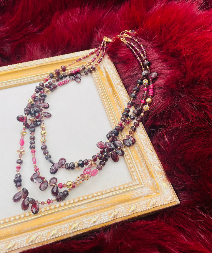 Nested 3 strand necklace featuring garnets, rubies, purple crystals, 14K gold accents, and African brass spacers. Available only from Rockstar Cowgirl online or in store in Cody, Wyoming.