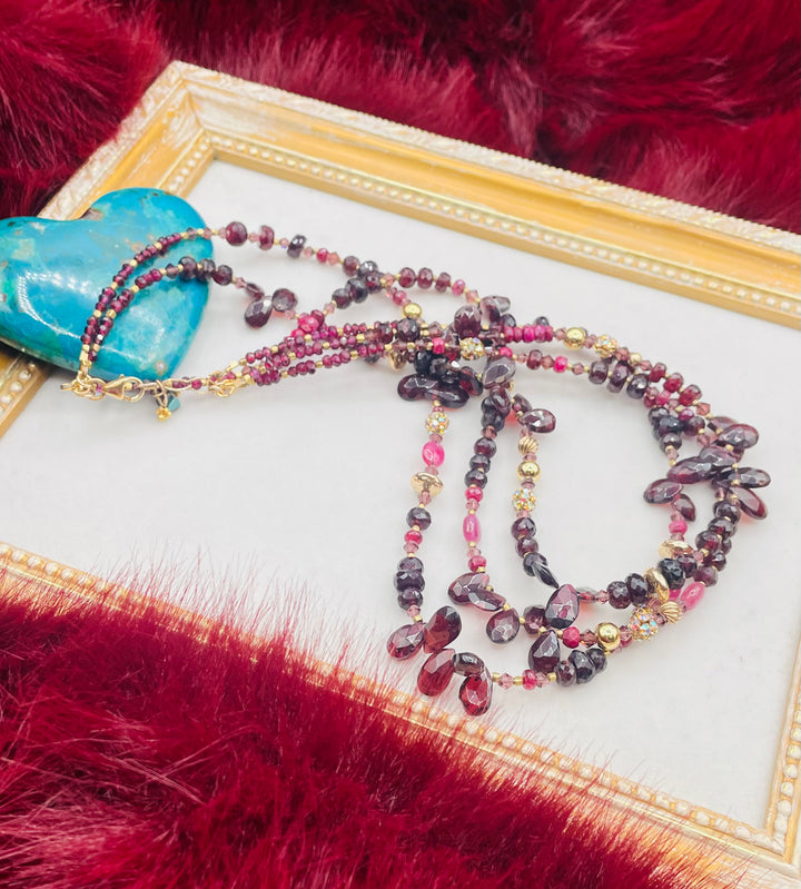 Nested 3 strand necklace featuring garnets, rubies, purple crystals, 14K gold accents, and African brass spacers. Available only from Rockstar Cowgirl online or in store in Cody, Wyoming.