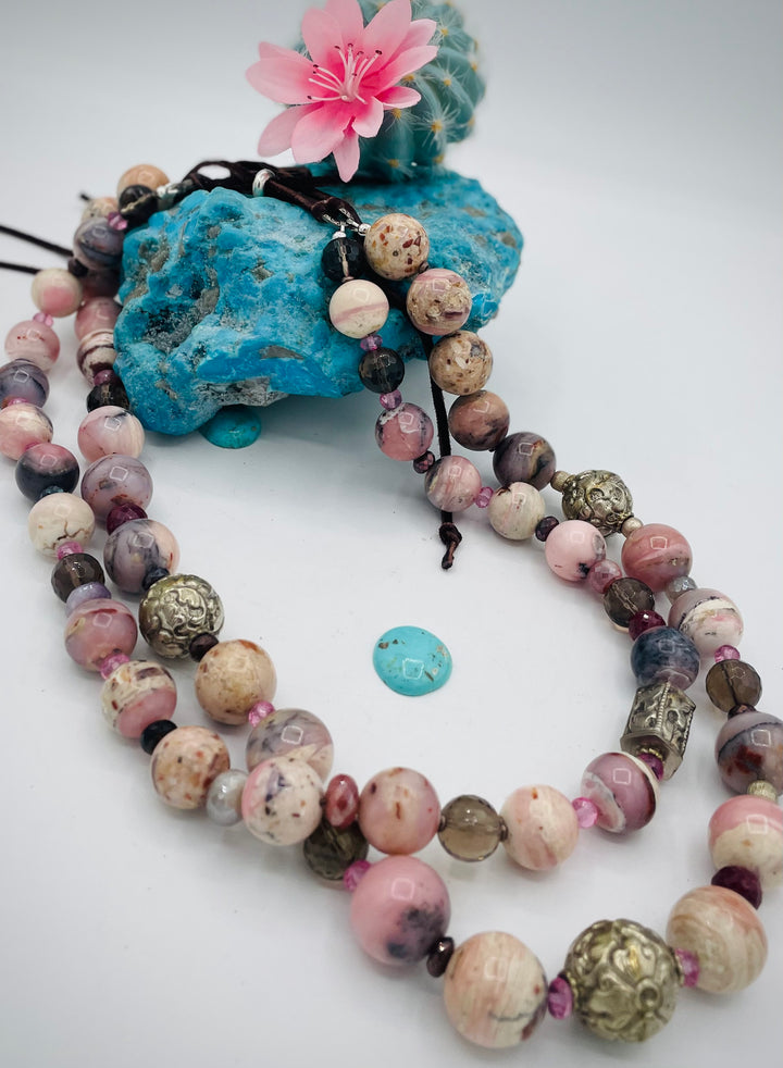 Beaded necklace featuring pink opal, repousse beads, smokey quartz, ruby, pink topaz, sterling silver beads, moonstone, and finished with deer lace in the back. Available only from Rockstar Cowgirl online or in store in Cody, Wyoming.