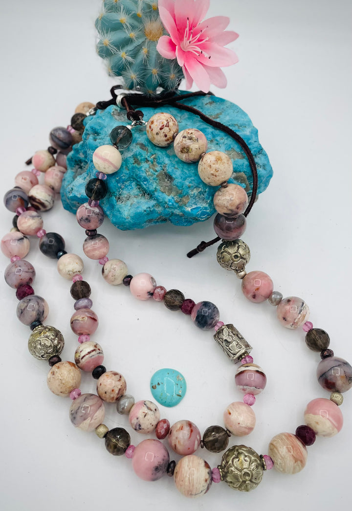 Beaded necklace featuring pink opal, repousse beads, smokey quartz, ruby, pink topaz, sterling silver beads, moonstone, and finished with deer lace in the back. Available only from Rockstar Cowgirl online or in store in Cody, Wyoming.