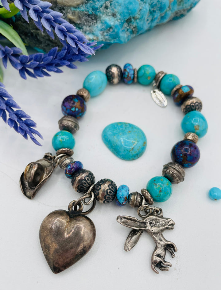 Stretch bracelet featuring Kingman turquoise, purple Mojave turquoise, sterling silver beads, and vintage sterling silver charms. Available only from Rockstar Cowgirl online or in store in Cody, Wyoming.