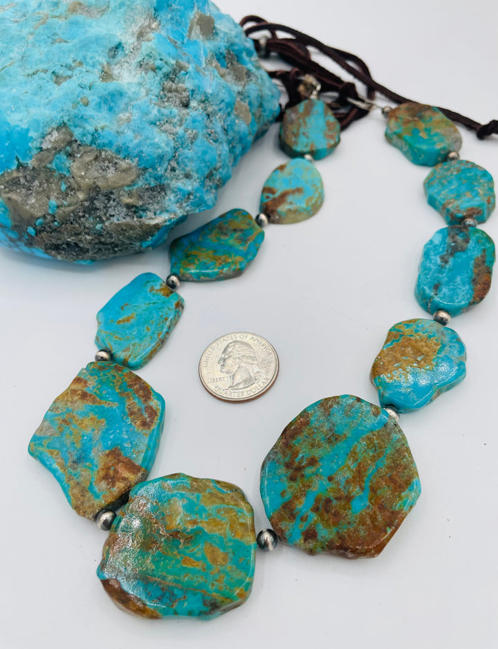 Adjustable beaded hatband featuring Kingman turquoise, and sterling silver beads finished with deer lace in the back. U.S. quarter for size reference. Available only from Rockstar Cowgirl online or in store in Cody, Wyoming.