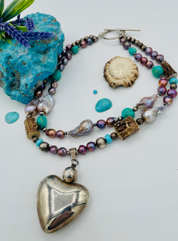 Fruity’s necklace features purple Edison pearls, Kingman turquoise nuggets and rondells, vintage sterling silver beads, deer antler, flameball pearls, and a sterling silver puffy heart pendant. Available only from Rockstar Cowgirl online or in store in Cody, Wyoming.