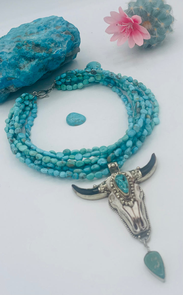 7 stranded beaded necklace featuring Sonoran turquoise nuggets, and a hand carved steer pendent with turquoise details. Available only from Rockstar Cowgirl online or in store in Cody, Wyoming.