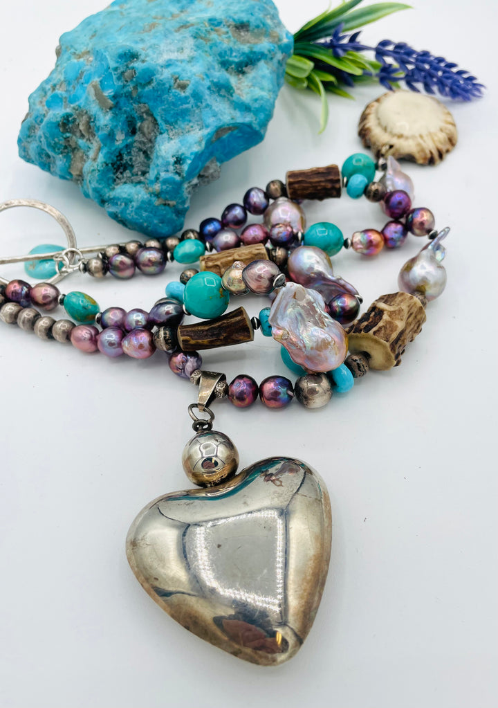 Fruity’s necklace features purple Edison pearls, Kingman turquoise nuggets and rondells, vintage sterling silver beads, deer antler, flameball pearls, and a sterling silver puffy heart pendant. Available only from Rockstar Cowgirl online or in store in Cody, Wyoming.