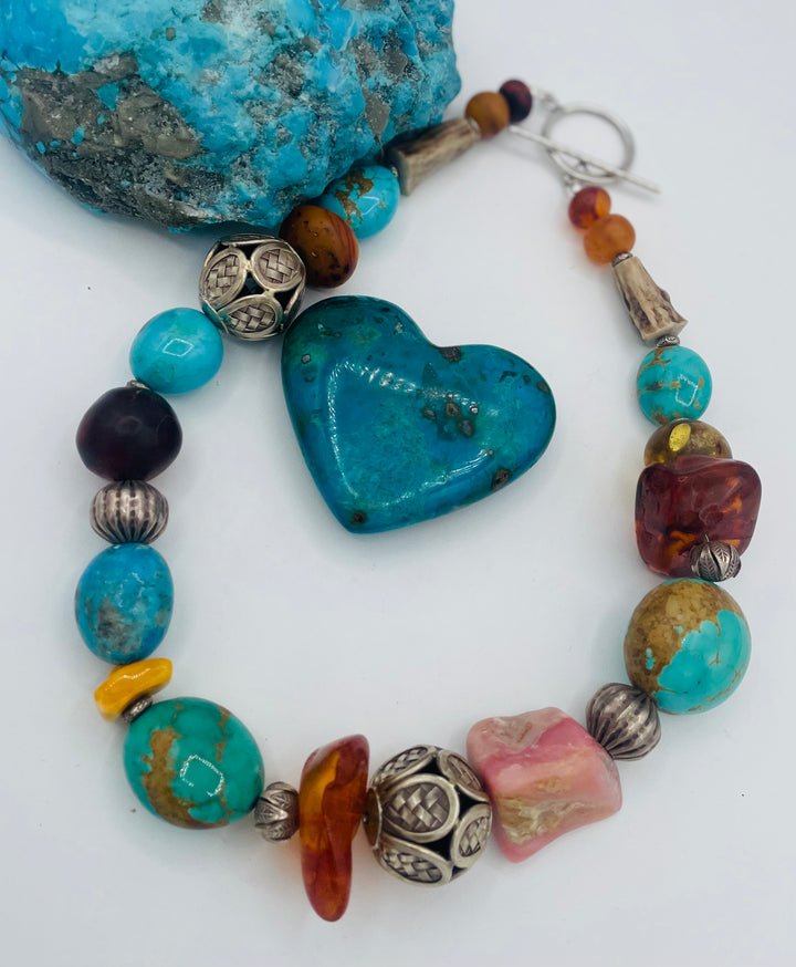 Chunky beaded necklace featuring Kingman turquoise, Ithaca Peak turquoise, textured deer antler, Baltic amber, pink opal, and sterling silver beads. Available only from Rockstar Cowgirl online or in store in Cody, Wyoming.