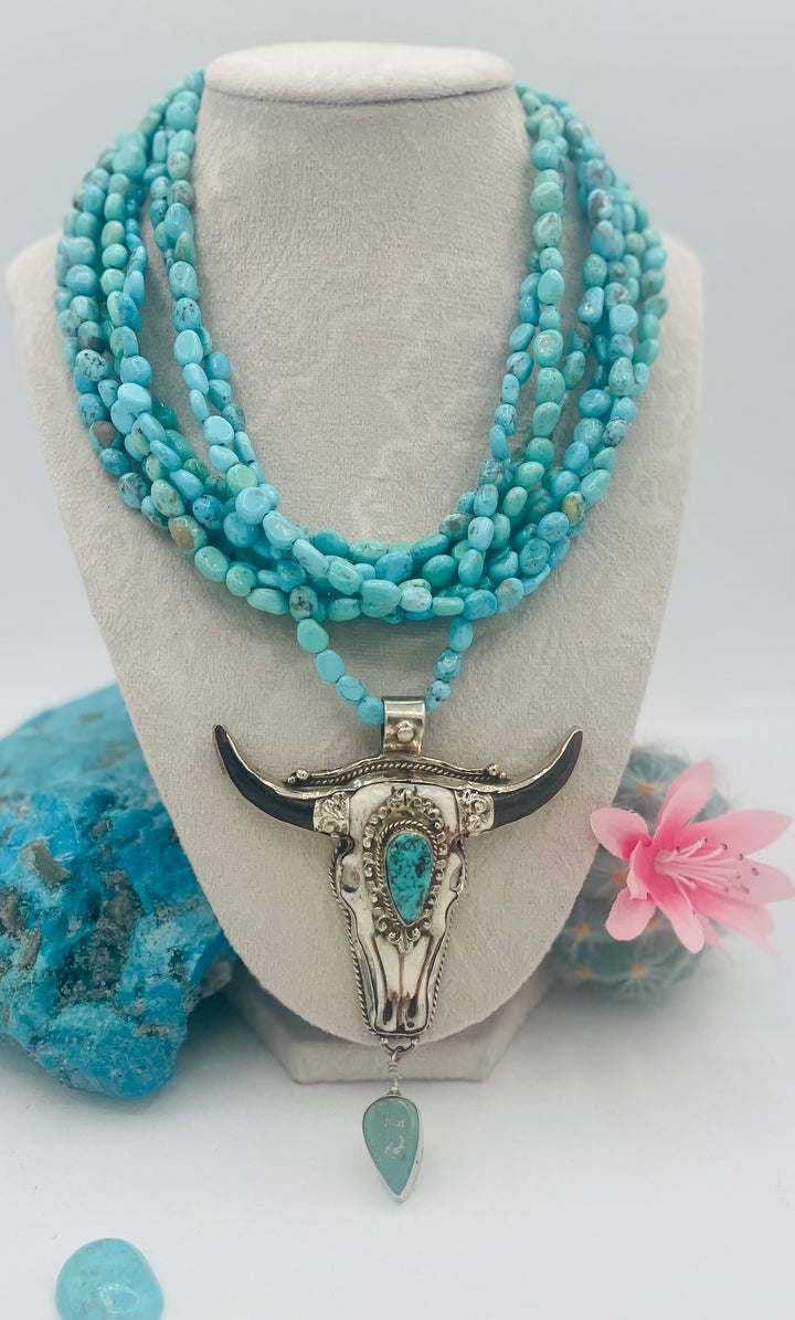 7 stranded beaded necklace featuring Sonoran turquoise nuggets, and a hand carved steer pendent with turquoise details. Available only from Rockstar Cowgirl online or in store in Cody, Wyoming.