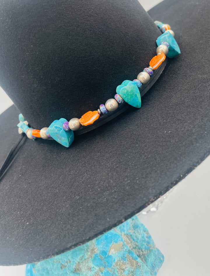 Adjustable beaded hatband featuring Kingman turquoise, purple Mojave turquoise, spiney oyster and turquoise hearts, sterling silver beads, and finished with deer lace in the back. Available only from Rockstar Cowgirl online or in store in Cody, Wyoming.