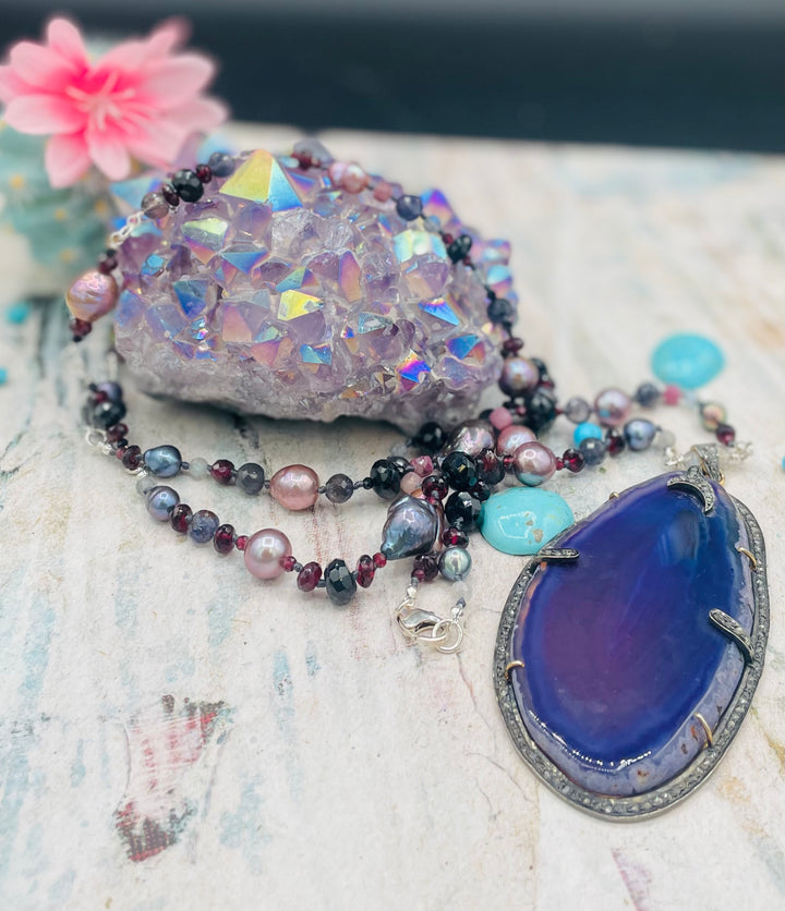 Silk knotted and wire wrapped treasure necklace featuring Peacock pearls, Edison natural luster pearls, spinel, garnets, iolite, labradorite, rainbow tourmaline, and a purple agate, sterling silver, and diamond pendent. Available only from Rockstar Cowgirl online or in store in Cody, Wyoming.