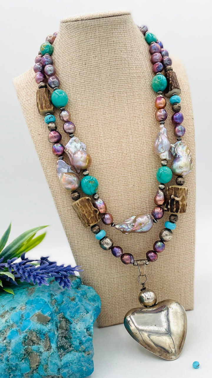 Fruity’s necklace features purple Edison pearls, Kingman turquoise nuggets and rondells, vintage sterling silver beads, deer antler, flameball pearls, and a sterling silver puffy heart pendant. Available only from Rockstar Cowgirl online or in store in Cody, Wyoming.