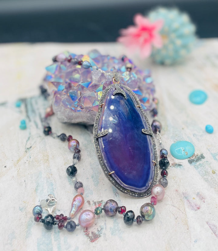 Silk knotted and wire wrapped treasure necklace featuring Peacock pearls, Edison natural luster pearls, spinel, garnets, iolite, labradorite, rainbow tourmaline, and a purple agate, sterling silver, and diamond pendent. Available only from Rockstar Cowgirl online or in store in Cody, Wyoming.