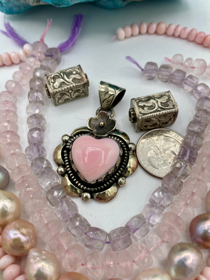 Bead box featuring strands of silverite, ruby, pearls, peridot, moonstone, opal, rose quartz, pink amethyst, with Repousse beads, and a pink conch shell pendant. U.S. quarter for size reference. Available only from Rockstar Cowgirl online or in store in Cody,Wyoming.