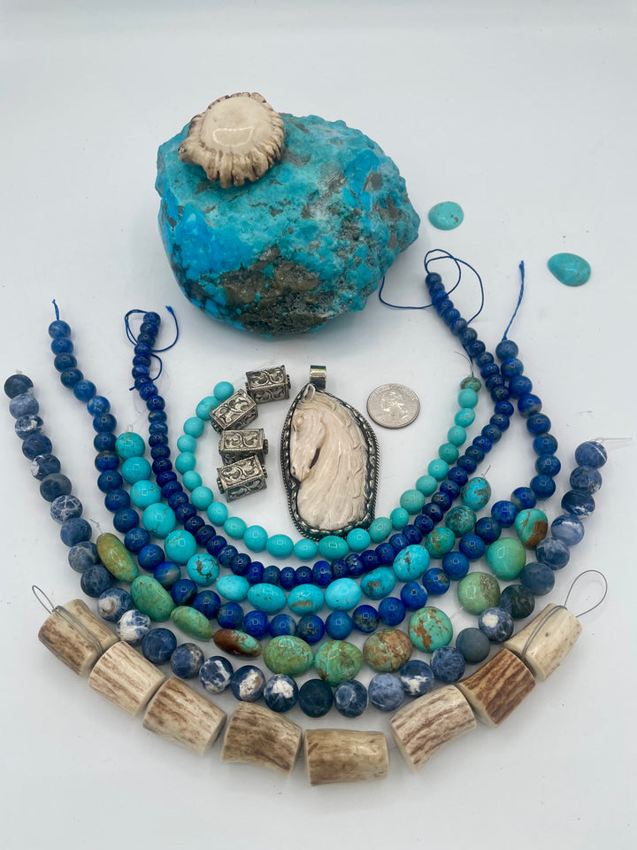 Bead box featuring strands of Elk antler beads, sodalite, Kingman turquoise in blue and green, denim lapis, repousse beads, and hand carved bone horse pendent in Bali silver. U.S. quarter for size reference. One of a kind box available only from Rockstar Cowgirl online or in store in Cody, Wyoming.