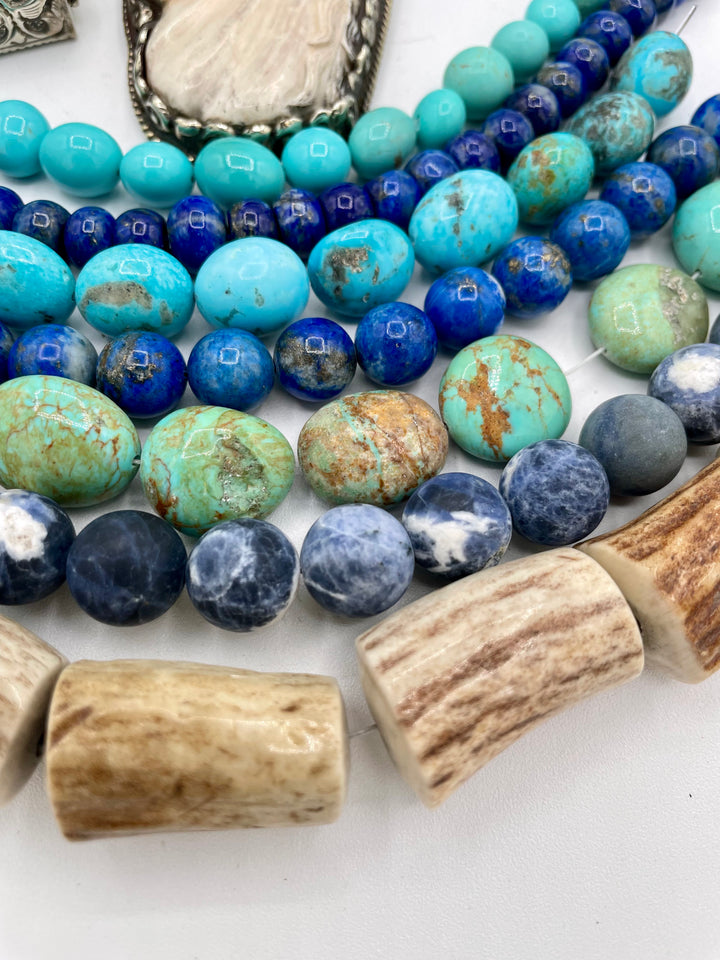Bead box featuring strands of Kingman turquoise in blue and green, sodalite, denim lapis, Campitios turquoise, repousse beads, and hand carved bone horse pendent in Bali silver. U.S. quarter for size reference. One of a kind box available only from 
Rockstar Cowgirl online or in store in Cody, Wyoming.