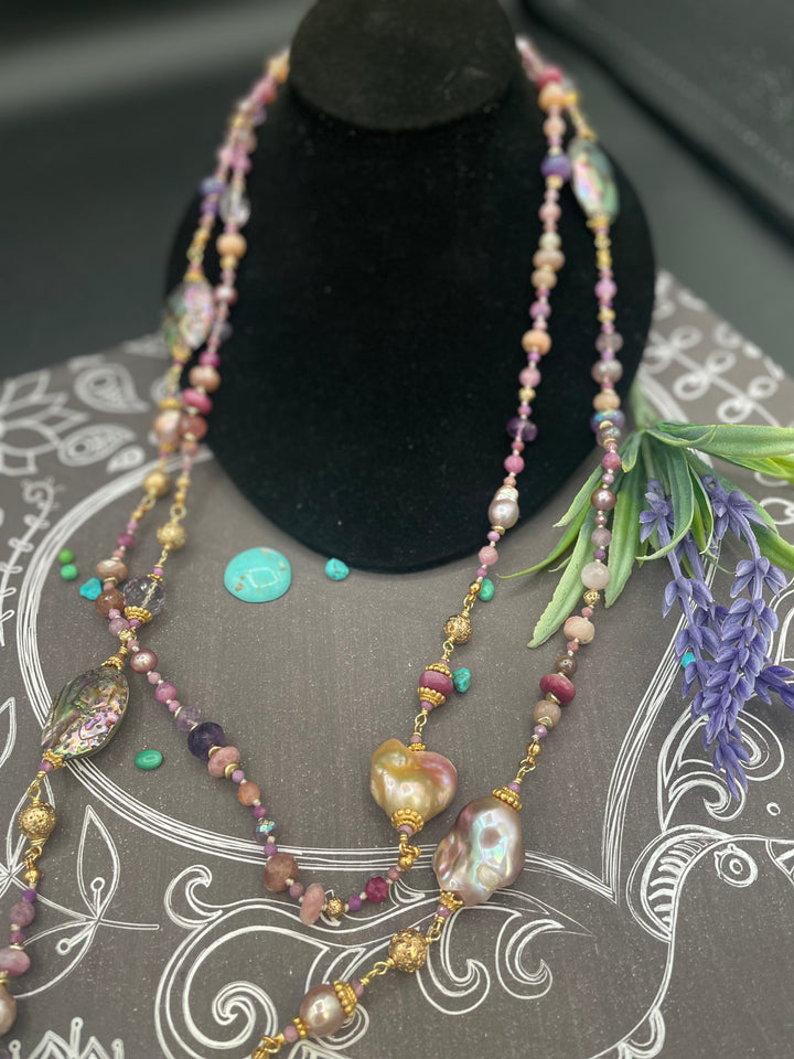 Silk knotted and wire wrapped treasure necklace featuring rubies, pink amethyst, pink tourmaline, moonstone, abalone shells, and natural luster baroque pearls. Available only from Rockstar Cowgirl online or in store in Cody, Wyoming.