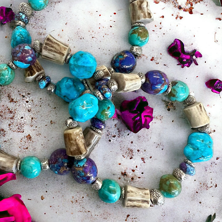 A close up of the blue and purple Mojave turquoise with deer antler and sterling silver beads.