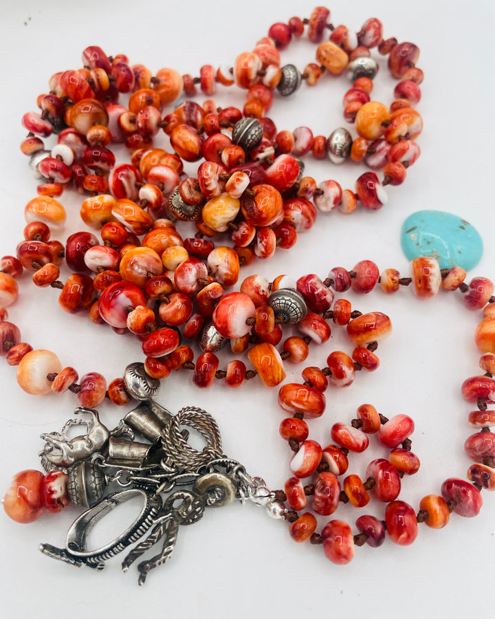 Silk knotted lariat necklace featuring spiney oyster, sterling silver stamped beads, and vintage sterling silver western charms. Available only from Rockstar Cowgirl online or in store in Cody, Wyoming.