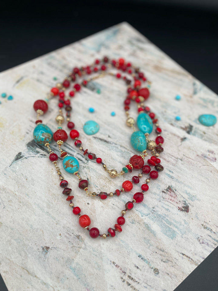 Silk knotted and wire wrapped extra long treasure necklace featuring Kingman Turquoise, red coral, red travertine beads, vintage Japanese cherry beads, and gold lava beads. Available only from Rockstar Cowgirl online or in store in Cody, Wyoming.