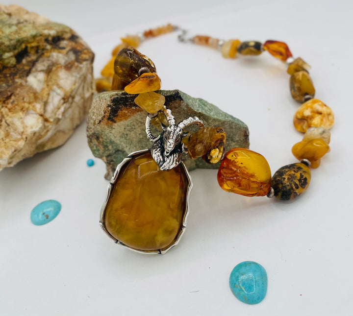 Beaded necklace featuring Baltic amber nuggets and chips, citrine nuggets, sterling silver beads, with a sterling silver and Baltic amber mountain goat pendent. Available only from Rockstar Cowgirl online or in store in Cody, Wyoming.