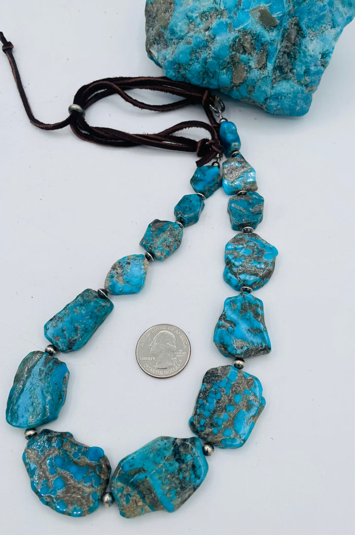 Adjustable beaded hatband that doubles as a necklace featuring Ithaca Peak turquoise and sterling silver beads and finished with deer lace in the back. U.S. quarter for size reference. Available only from Rockstar Cowgirl online or in store in Cody,, Wyoming.