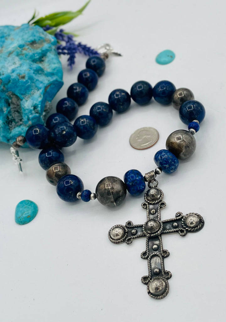 Chunky beaded necklace featuring lapis lazuli and sterling silver beads with a sterling silver cross. U.S. quarter for size reference. Available only from Rockstar Cowgirl online or in store in Cody, Wyoming.