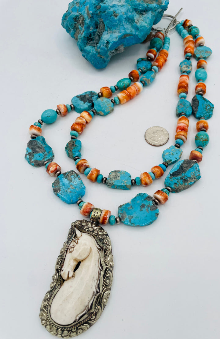 Beaded 2 strand necklace featuring Kingman turquoise, spiney oyster, sterling silver beads, with a bone and Bali silver horse pendent. U.S. quarter for size reference. Available only from Rockstar Cowgirl online or in store in Cody, Wyoming.