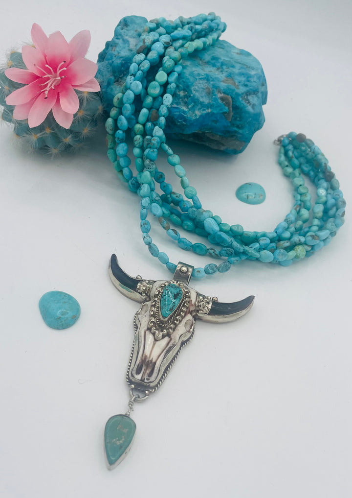 7 stranded beaded necklace featuring Sonoran turquoise nuggets, and a hand carved steer pendent with turquoise details. Available only from Rockstar Cowgirl online or in store in Cody, Wyoming.
