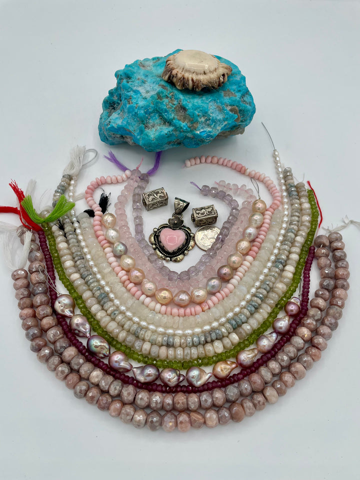 Bead box featuring strands of silverite, ruby, pearls, peridot, moonstone, opal, rose quartz, pink amethyst, with Repousse beads, and a pink conch shell pendant. U.S. quarter for size reference. Available only from Rockstar Cowgirl online or in store in Cody,Wyoming.