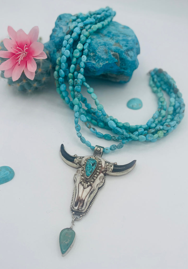 7 stranded beaded necklace featuring Sonoran turquoise nuggets, and a hand carved steer pendent with turquoise details. Available only from Rockstar Cowgirl online or in store in Cody, Wyoming.