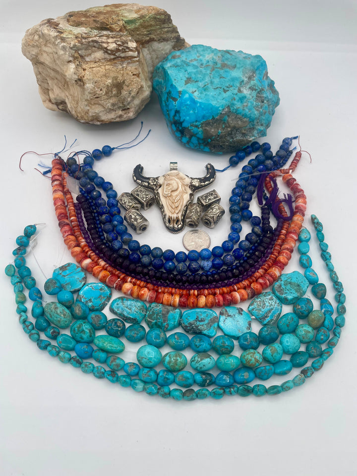 Bead box featuring strands of lapis, amethyst, spiney oyster, Kingman turquoise, Campitios turquoise, Repousse beads, with a bone and Bali silver steer pendent. U.S. quarter for size reference. Available only from Rockstar Cowgirl online or in store in Cody, Wyoming.
