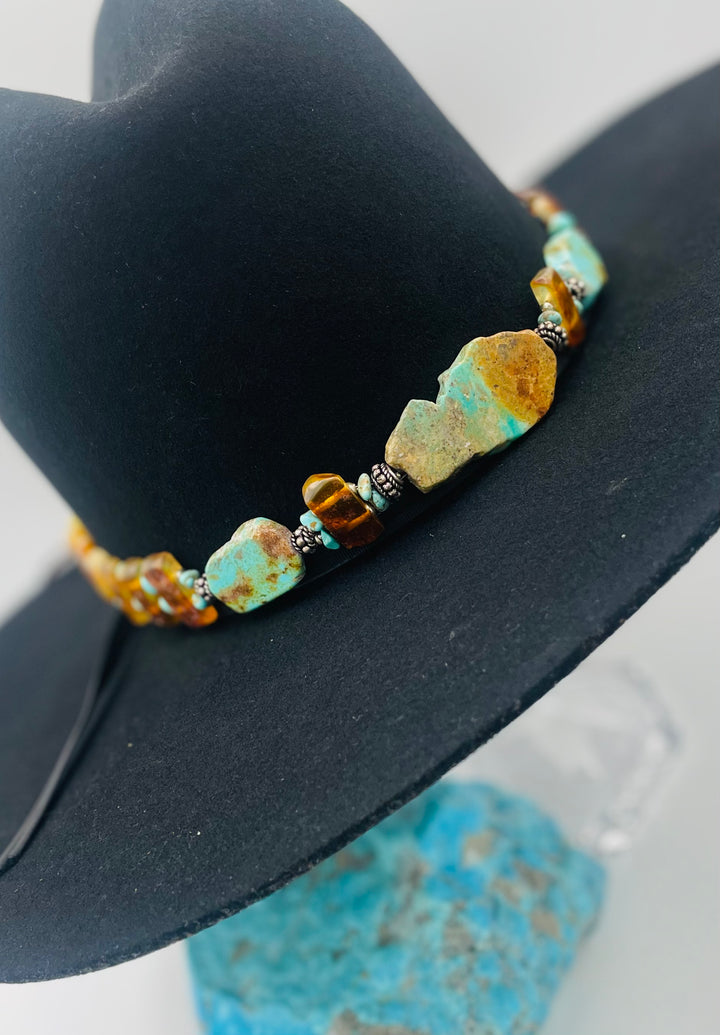 Adjustable beaded hatband featuring Kingman turquoise, Sonoran turquoise, Baltic amber with silver details, and finished with deer lace in the back. Available only from Rockstar Cowgirl online or in store in Cody, Wyoming.