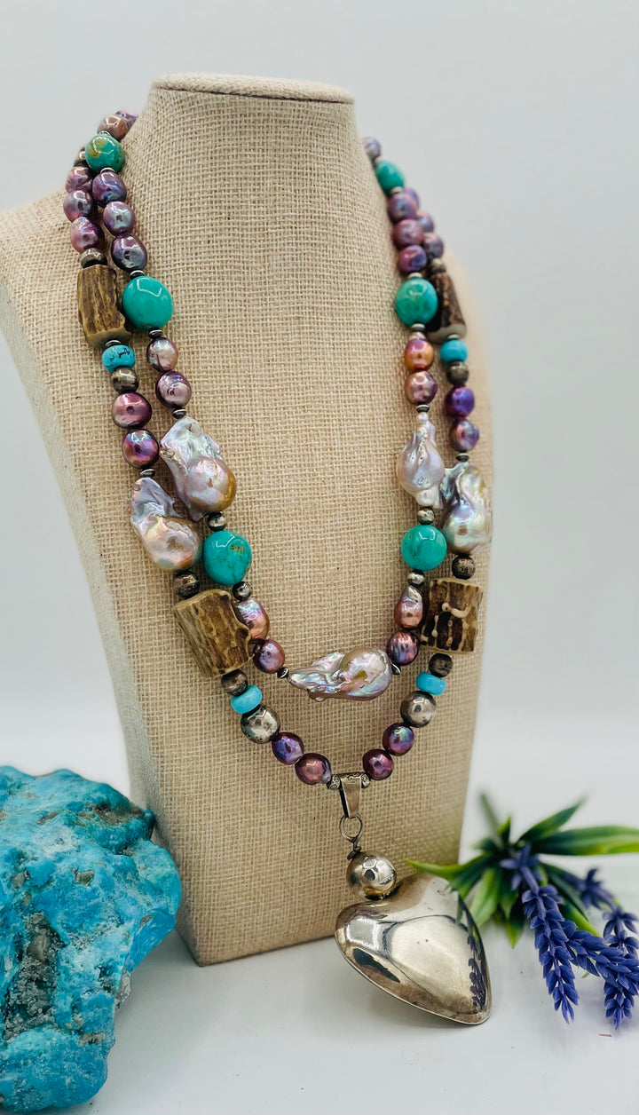Fruity’s necklace features purple Edison pearls, Kingman turquoise nuggets and rondells, vintage sterling silver beads, deer antler, flameball pearls, and a sterling silver puffy heart pendant. Available only from Rockstar Cowgirl online or in store in Cody, Wyoming.