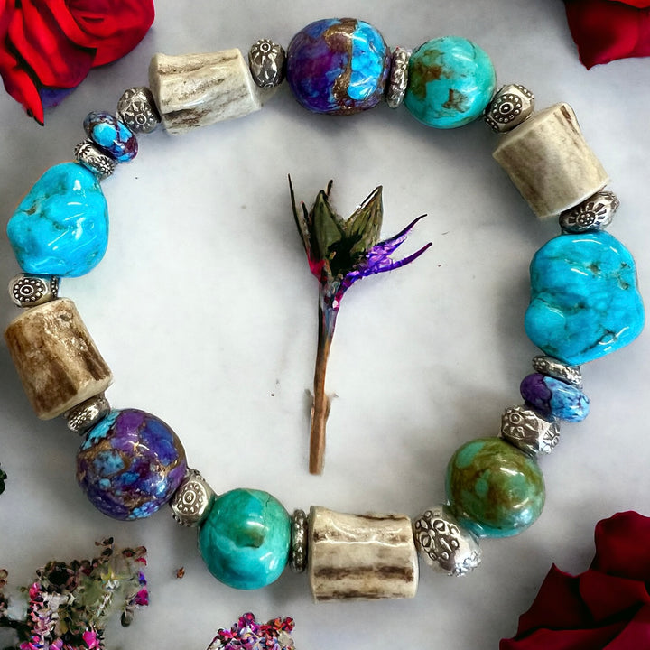 A stretch bracelet featuring blue Kingman and the purple Mojave turquoise with deer antler and hill tribe sterling silver beads.
