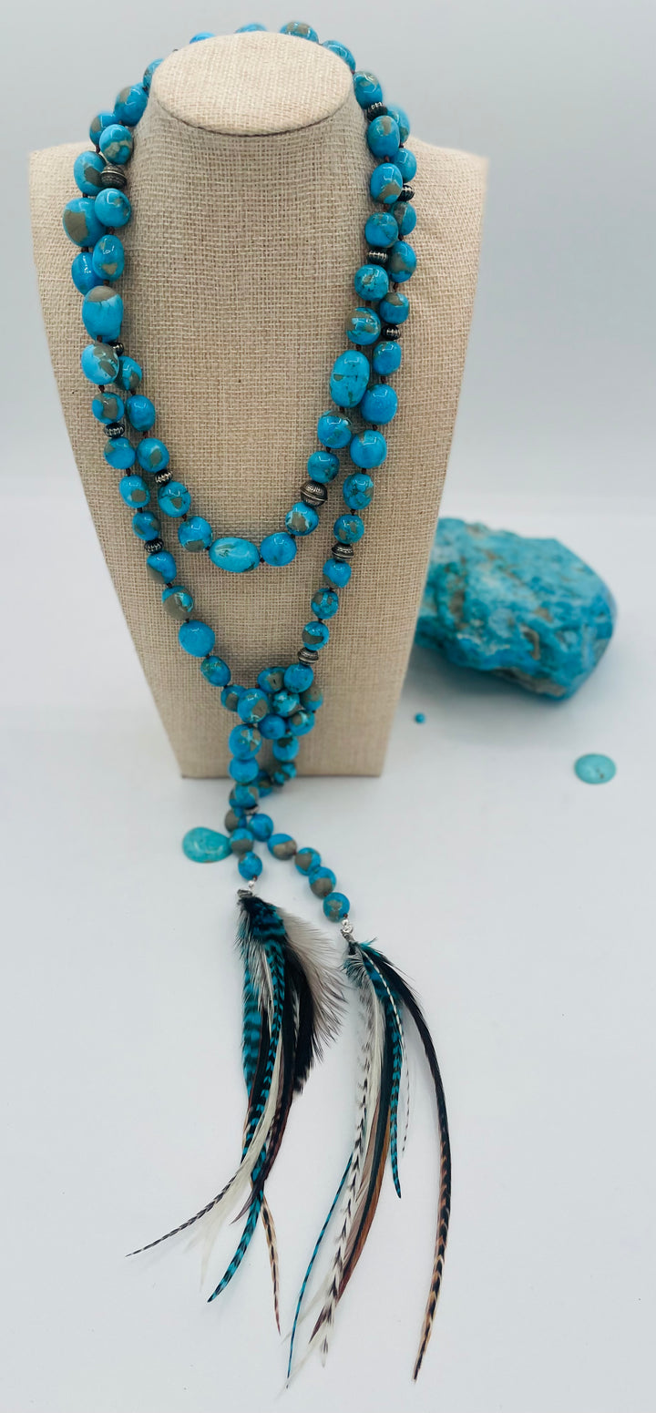 Silk knotted lariat featuring Ithaca peak turquoise, sterling silver beads, and feather tassels. Available only from Rockstar Cowgirl online or in store in Cody, Wyoming.