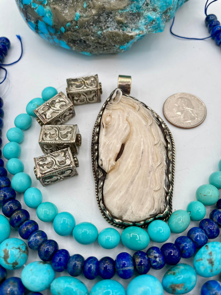 Bead box featuring strands of Kingman turquoise in blue and green, sodalite, denim lapis, Campitios turquoise, repousse beads, and hand carved bone horse pendent in Bali silver. U.S. quarter for size reference. One of a kind box available only from 
Rockstar Cowgirl online or in store in Cody, Wyoming.