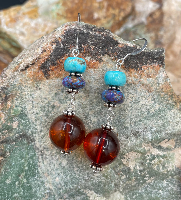 A close up of the earrings featuring Baltic amber rounds and two kinds of turquoise with sterling silver hooks.