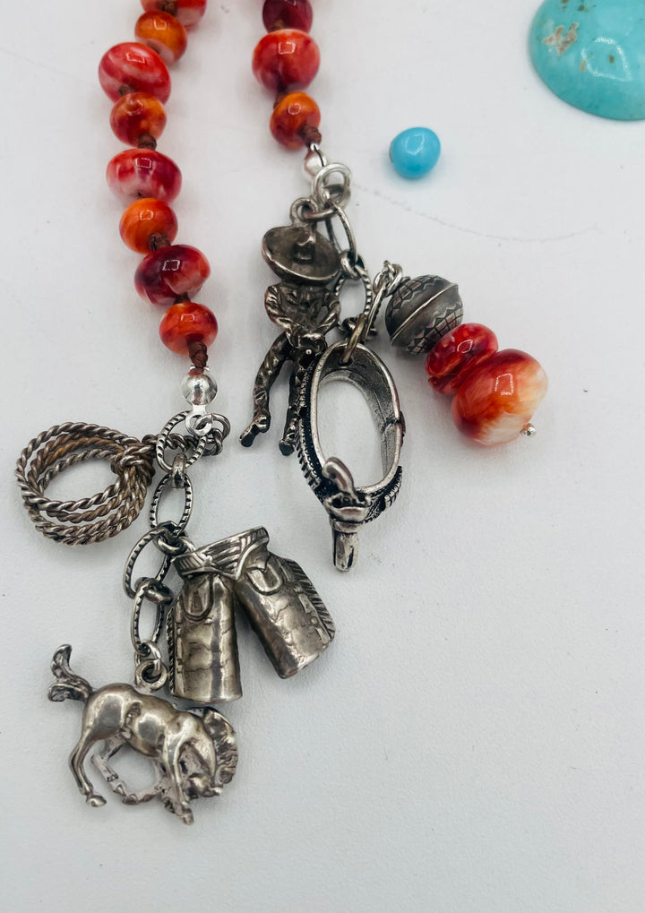 Silk knotted lariat necklace featuring spiney oyster, sterling silver stamped beads, and vintage sterling silver western charms. Available only from Rockstar Cowgirl online or in store in Cody, Wyoming.